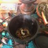 prosperity and abundance full moon spell a black cauldron with burning herbs sits among crystals and tarot cards on an altar draped in turquoise ankara fabric.